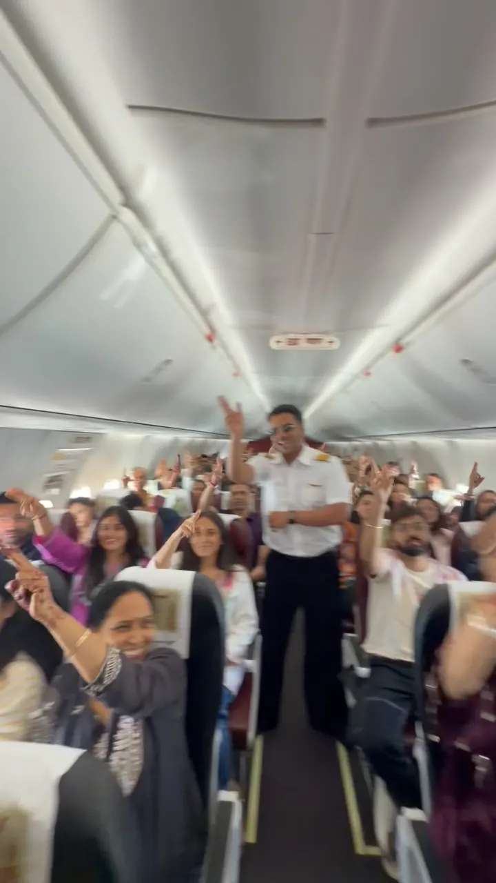 Chirag Vithalani in a pilot's uniform leading a dancing cabin on a wedding flight
